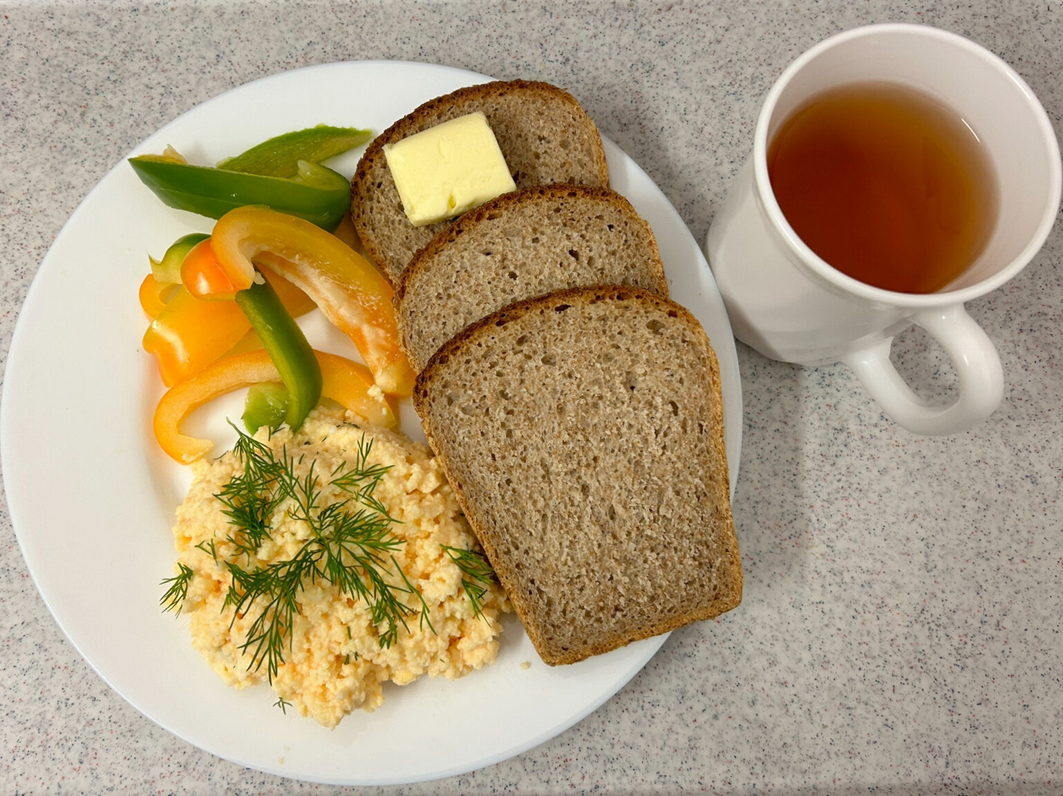 Na zdjęciu: Herbata czarna ekspresowa z cytryną Cateringowa, Chleb graham, Masło extra 82%, Pasta z jaj z koperkiem, Papryka świeża