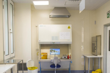 Zdjęcie przedstawia pomieszczenie z komorą do przygotowywania leków cytostatycznych