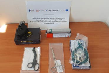 Zdjęcie przedstawia wyposażenie ambulansu tj. Rękojeść do laryngoskopu, Nożyczki do cięcia pasów (ratownicze), Nożyczki opatrunkowe (ratownicze), Kleszczyki naczyniowe PEAN oraz stetoskop
